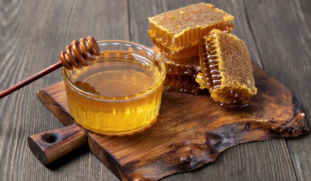 Honey and Honeycomb slice on wooden board 